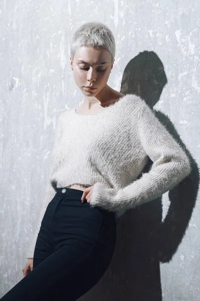 Beautiful blonde girl posing at the concrete wall — Stock Photo, Image