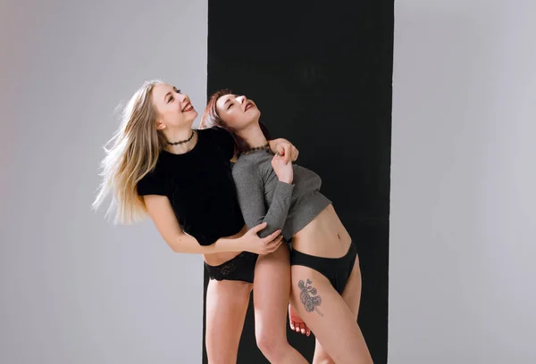 Two beautiful girlfriends in lingerie standing on a white background — Stock Photo, Image