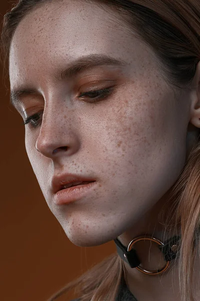 Портрет красивої дівчини з веснянками в студії на коричневому фоні — стокове фото