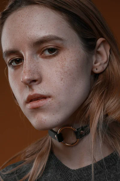 Portrait d'une belle fille avec des taches de rousseur en studio sur un fond brun — Photo