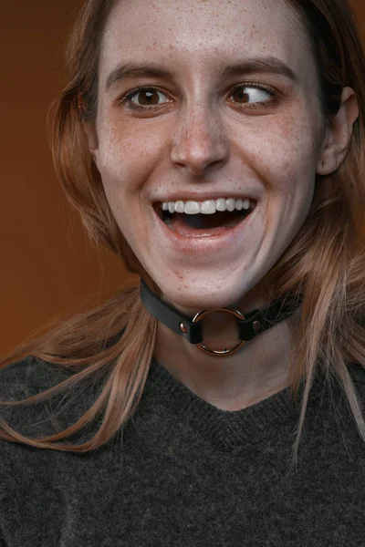 Retrato de uma menina bonita com sardas em estúdio em um fundo marrom — Fotografia de Stock