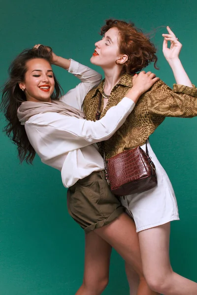 Zwei schöne Mädchen auf grünem Hintergrund — Stockfoto