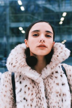Office caddenin bir arka plan üzerinde kürk paltolu güzel iş kadını