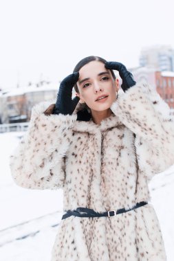 Office caddenin bir arka plan üzerinde kürk paltolu güzel iş kadını