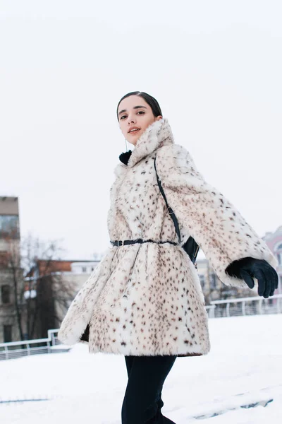 Beautiful business woman in a fur coat on a background of office on the street — Stock Photo, Image