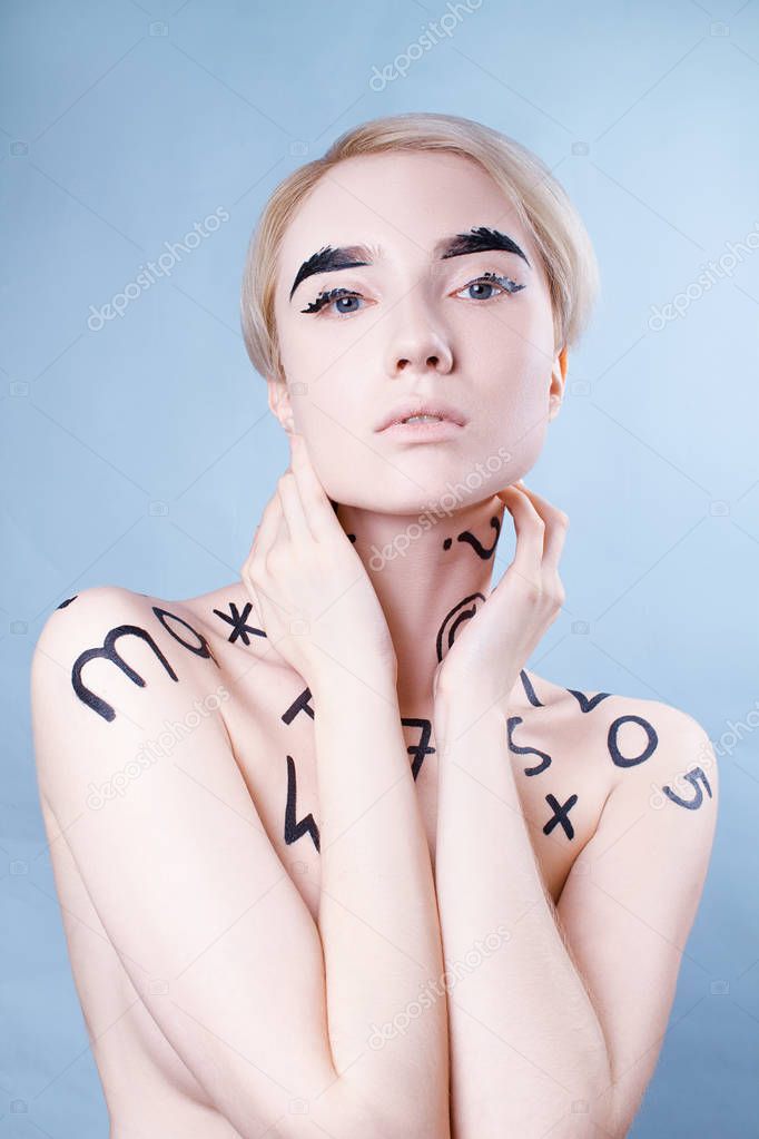 Portrait of a beautiful girl on a blue background with the inscriptions on the body