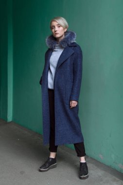 Sarışın kız gözlük ve bir kat ile şehrin sokaklarında yürüyor