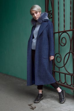 Sarışın kız gözlük ve bir kat ile şehrin sokaklarında yürüyor