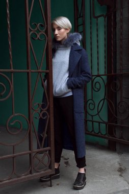 Sarışın kız gözlük ve bir kat ile şehrin sokaklarında yürüyor