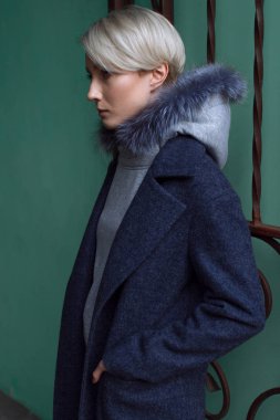 Sarışın kız gözlük ve bir kat ile şehrin sokaklarında yürüyor