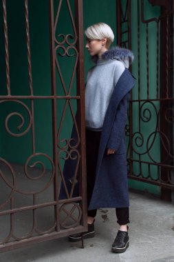 Sarışın kız gözlük ve bir kat ile şehrin sokaklarında yürüyor