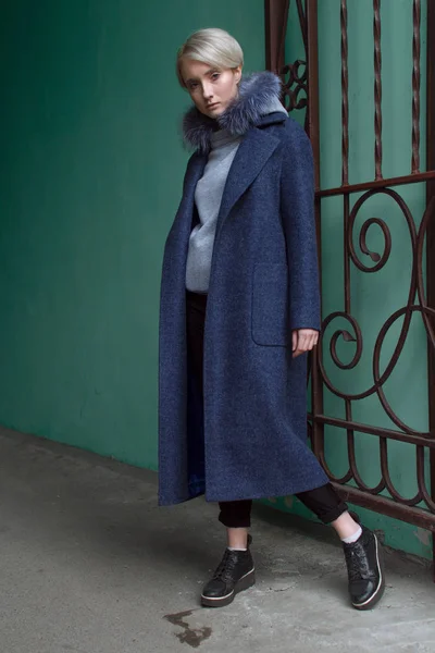 Sarışın kız gözlük ve bir kat ile şehrin sokaklarında yürüyor