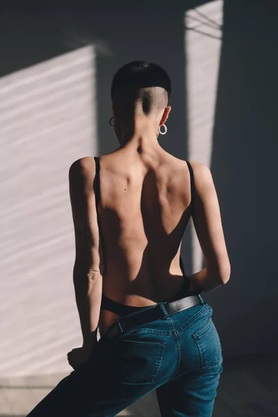 Atrakcyjna dziewczyna z doskonałego ciała i krótkie włosy pozowanie w dżinsy w słońcu — Zdjęcie stockowe