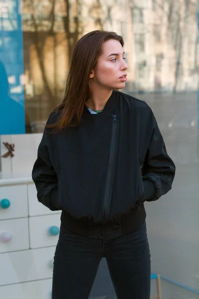 Молода і стильна дівчина в модному одязі йде по вулиці міста — стокове фото