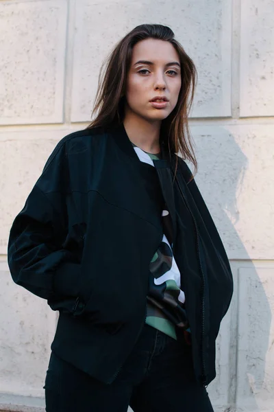 Молода і стильна дівчина в модному одязі йде по вулиці міста — стокове фото