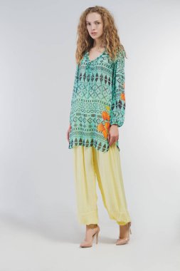 Studio moda giysileri beyaz bir arka plan üzerinde güzel kız