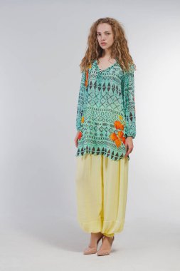 Studio moda giysileri beyaz bir arka plan üzerinde güzel kız