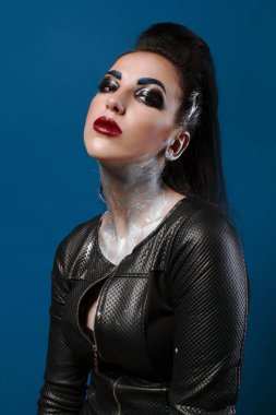 Mavi bir arka plan üzerinde yaratıcı makyajlı kız