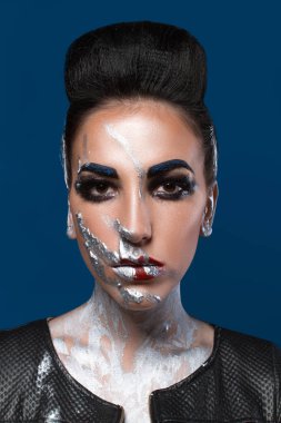 Mavi bir arka plan üzerinde yaratıcı makyajlı kız