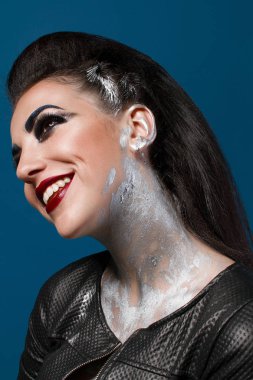 Mavi bir arka plan üzerinde yaratıcı makyajlı kız