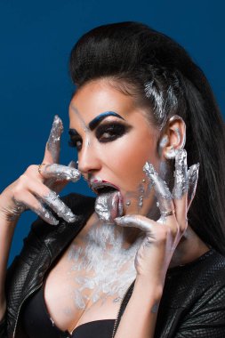 Mavi bir arka plan üzerinde yaratıcı makyajlı kız