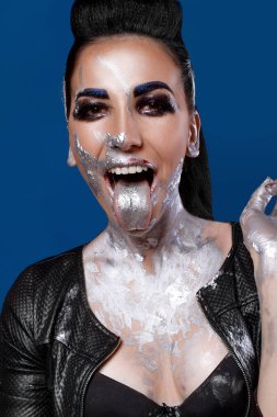 Mavi bir arka plan üzerinde yaratıcı makyajlı kız