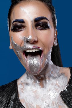 Mavi bir arka plan üzerinde yaratıcı makyajlı kız