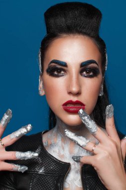 Mavi bir arka plan üzerinde yaratıcı makyajlı kız