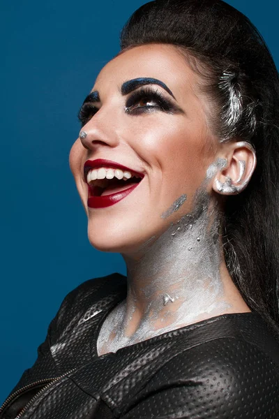 Mavi bir arka plan üzerinde yaratıcı makyajlı kız