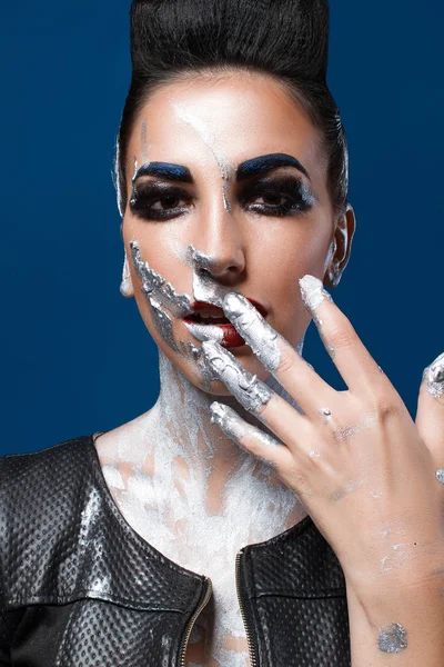 Mavi bir arka plan üzerinde yaratıcı makyajlı kız