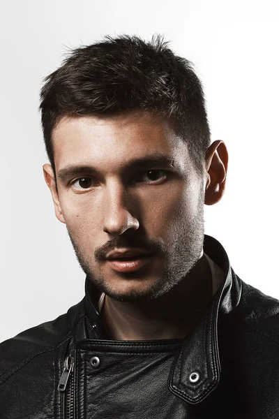 Fashionable male portrait in studio on a white background and in a leather jacket — Stock Photo, Image