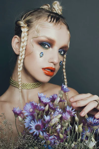 Portrait féminin à la mode en studio avec cheveux, maquillage et fleurs — Photo