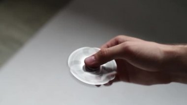 Bir erkek eli beyaz zemin üzerinde bir spinner oynuyor