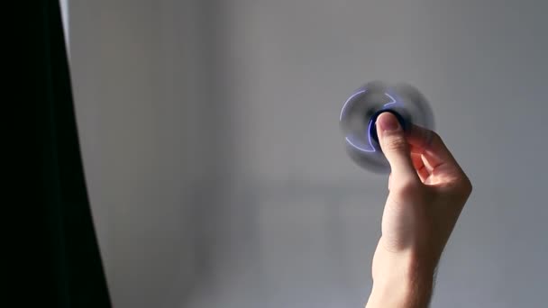 Iemands hand speelt in een spinner op een witte achtergrond — Stockvideo