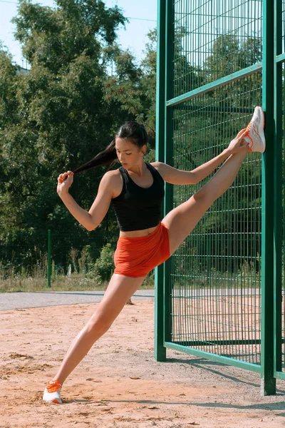 Belle fille sportive faisant de l'exercice par une matinée ensoleillée au stade — Photo