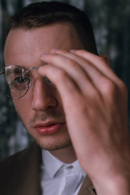 Yağmurluk ve gözlük farklı ruh halleri ile yalnız bir yakışıklı adam