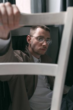 Yağmurluk ve gözlük farklı ruh halleri ile yalnız bir yakışıklı adam