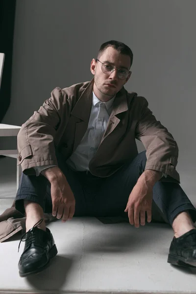 A lonely handsome guy in a raincoat and glasses with different moods — Stock Photo, Image