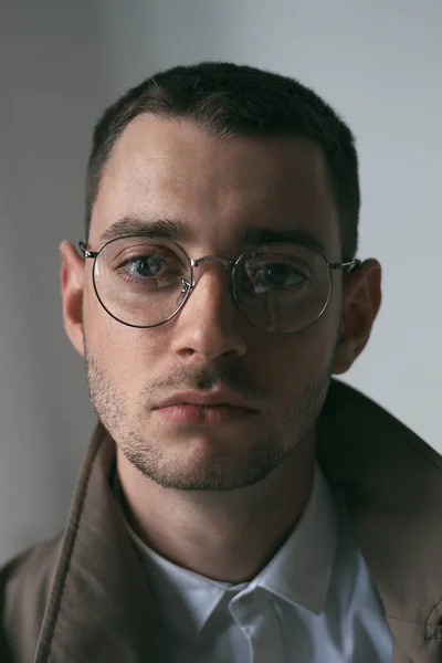 Seorang pria tampan kesepian dengan jas hujan dan kacamata dengan suasana hati yang berbeda — Stok Foto
