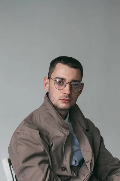 Seorang pria tampan kesepian dengan jas hujan dan kacamata dengan suasana hati yang berbeda — Stok Foto