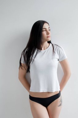 Güzel esmer siyah iç çamaşırı ve parlak bir odada beyaz bir gömlek