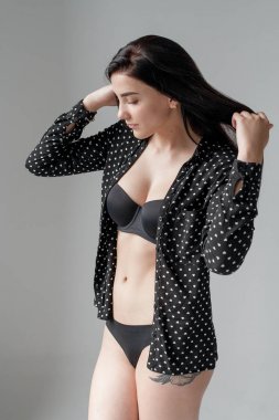 Güzel esmer siyah iç çamaşırı ve parlak bir odada bir gömlek