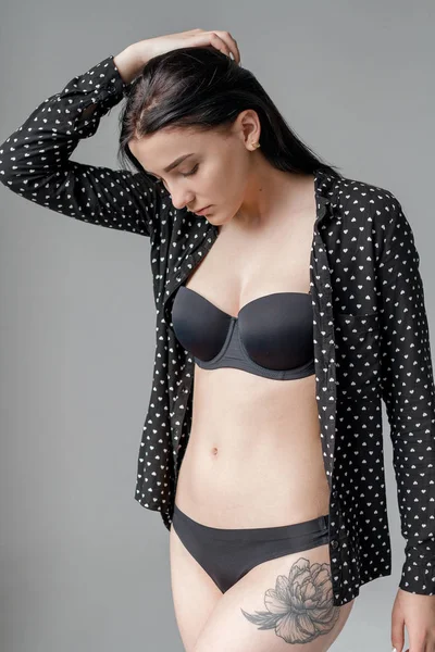 Güzel esmer siyah iç çamaşırı ve parlak bir odada bir gömlek