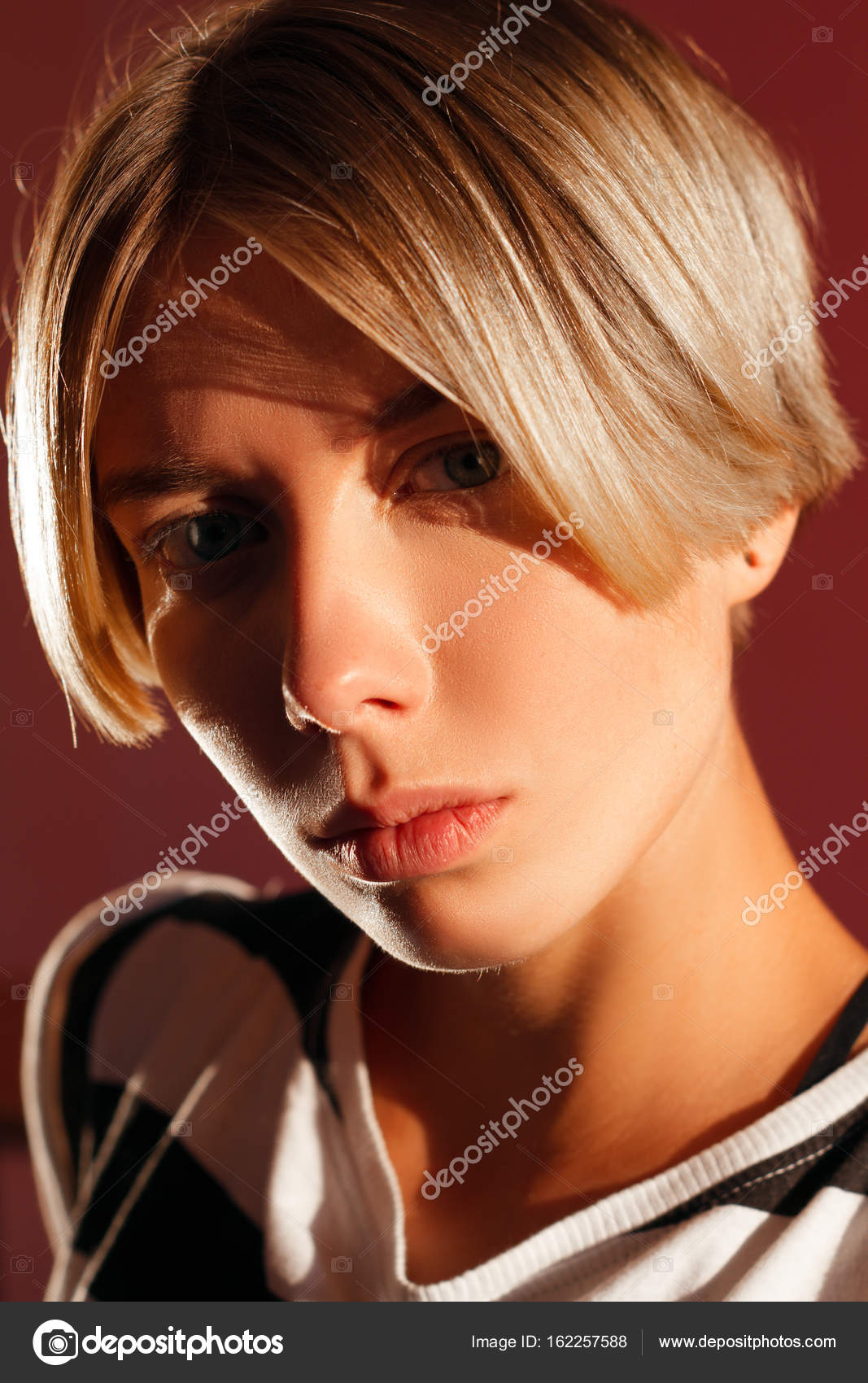 Beautiful Girl With Short Haircut And Sporty Figure On A Red