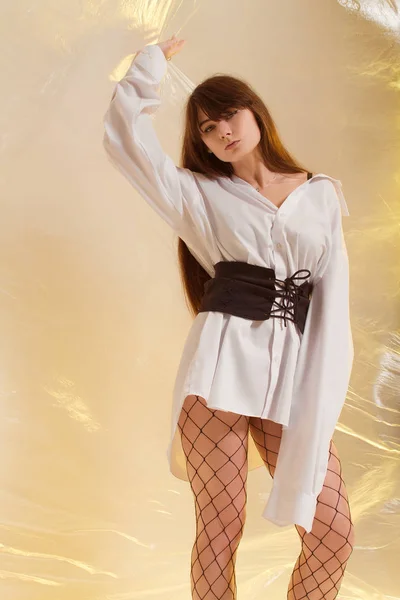 반투명 필름의 배경에서 유행 옷에서 세련 된 소녀 — 스톡 사진