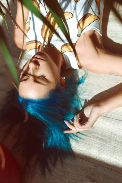 Piękna, szczupła dziewczyna w majtki i koszulkę z niebieskie włosy pozowanie na podłodze obok kwiat w doniczce — Zdjęcie stockowe