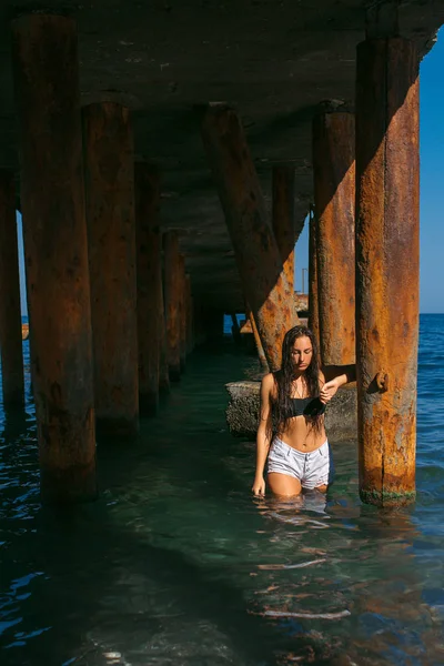 Kız ıslak saçlı, güzel rakam ve temiz cilt deniz güneşli havalarda karşı sahilde