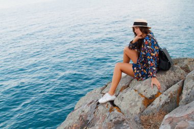 Güzel kız elbise ve denize karşı dağlarda şapkalı