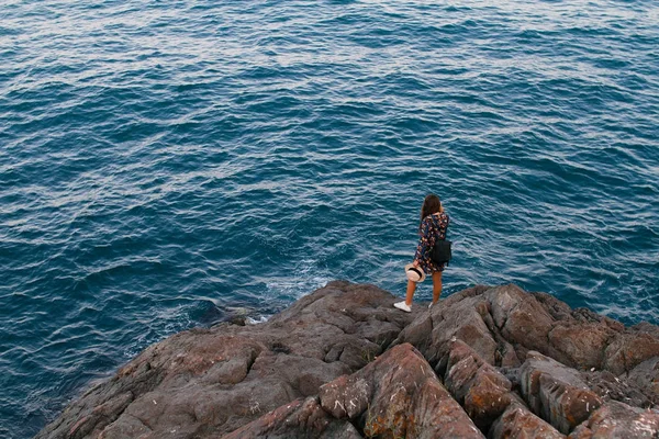 Bella ragazza in un vestito e con un cappello in montagna contro il mare — Foto Stock