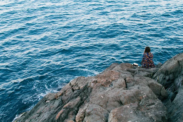 Bella ragazza in un vestito e con un cappello in montagna contro il mare — Foto Stock